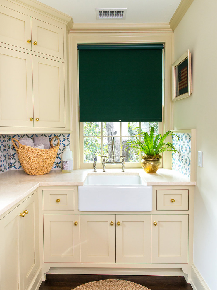 Immagine di una lavanderia tradizionale con lavello stile country, ante in stile shaker, ante beige, pareti beige, parquet scuro e top beige