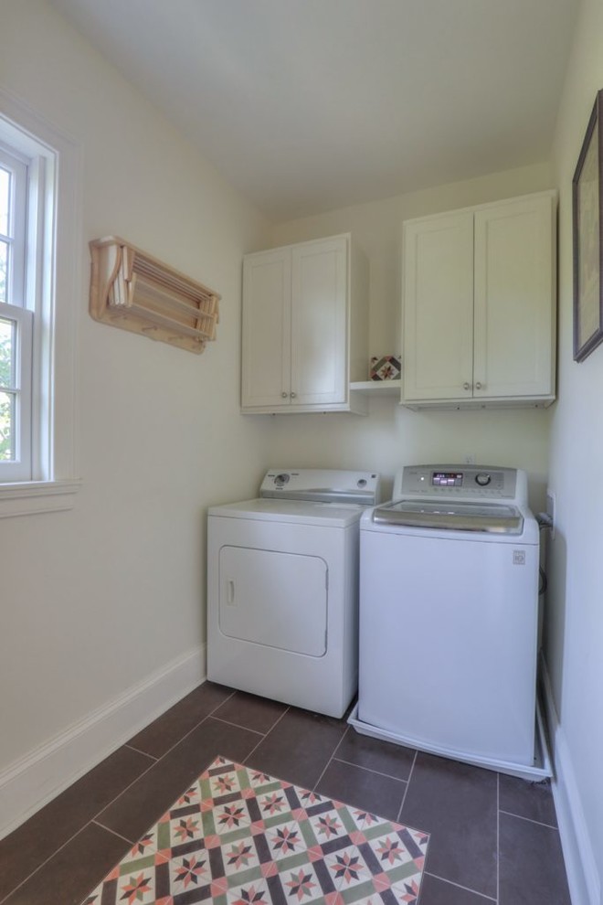 Kleine Klassische Waschküche mit Schrankfronten im Shaker-Stil, weißen Schränken, weißer Wandfarbe, Keramikboden, Waschmaschine und Trockner nebeneinander und grauem Boden in Nashville