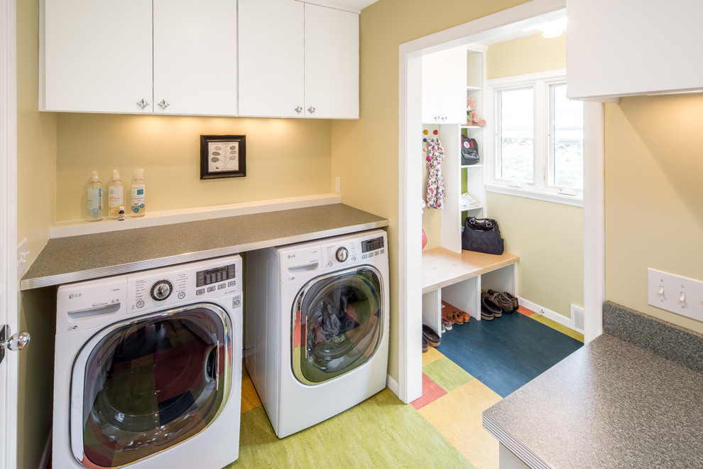 Foto de lavadero de galera y multiusos retro de tamaño medio con armarios con paneles lisos, puertas de armario blancas, paredes beige y lavadora y secadora juntas