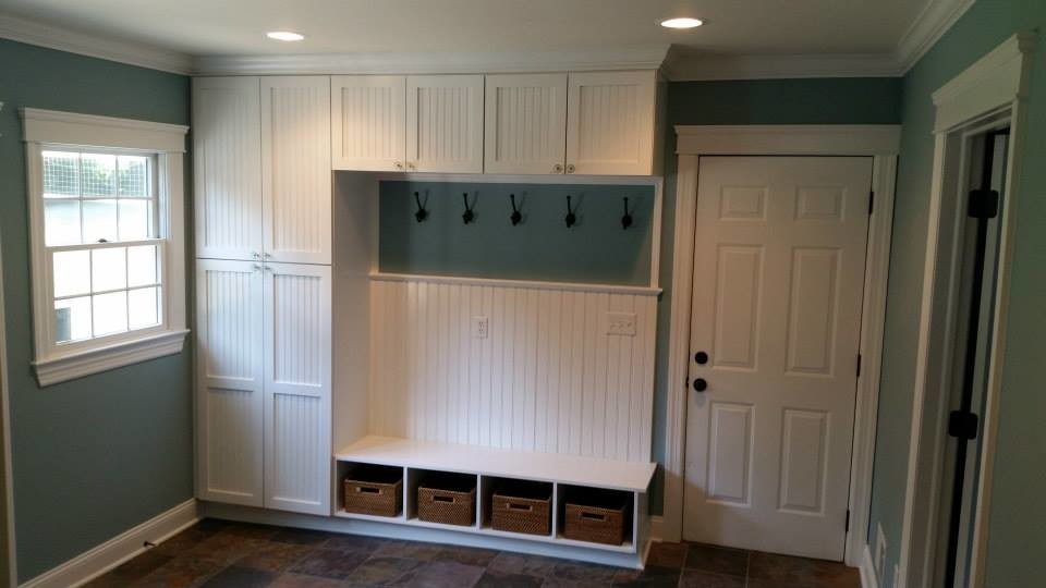 Large trendy single-wall slate floor utility room photo in Newark with shaker cabinets, white cabinets, blue walls and a stacked washer/dryer