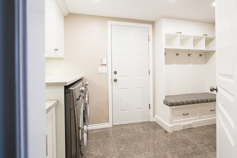 Immagine di una sala lavanderia minimalista di medie dimensioni con lavello sottopiano, ante in stile shaker, ante bianche, pareti beige, pavimento con piastrelle in ceramica, lavatrice e asciugatrice affiancate e pavimento grigio