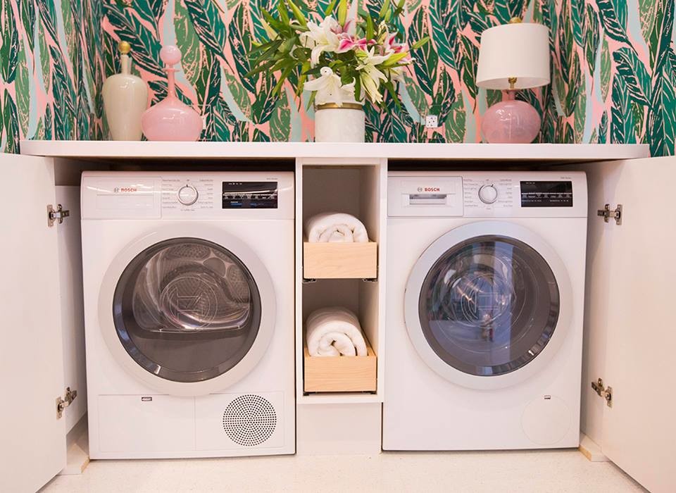 Immagine di una piccola sala lavanderia tropicale con ante bianche, top in superficie solida, pareti multicolore, pavimento con piastrelle in ceramica e lavatrice e asciugatrice nascoste