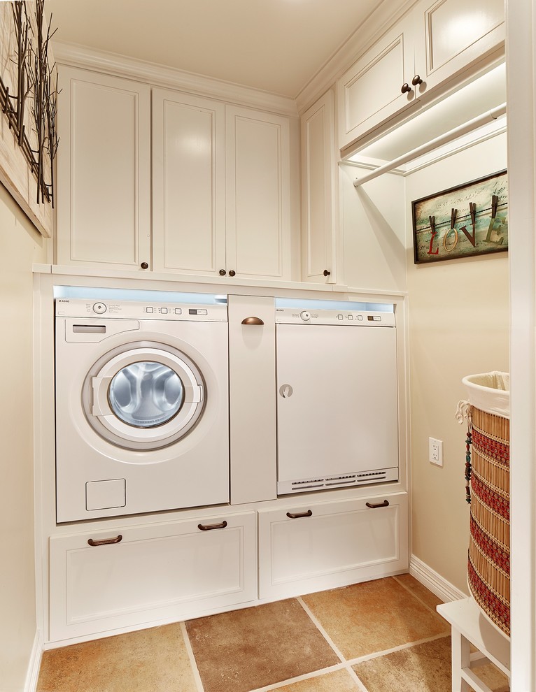 ダラスにあるサンタフェスタイルのおしゃれなランドリールーム (白いキャビネット、白い壁、磁器タイルの床、左右配置の洗濯機・乾燥機) の写真