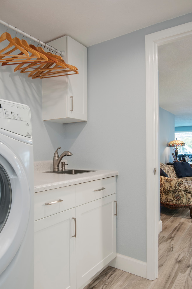 Exempel på en mellanstor maritim vita parallell vitt tvättstuga enbart för tvätt, med en nedsänkt diskho, skåp i shakerstil, vita skåp, bänkskiva i koppar, blå väggar, klinkergolv i keramik, en tvättmaskin och torktumlare bredvid varandra och beiget golv