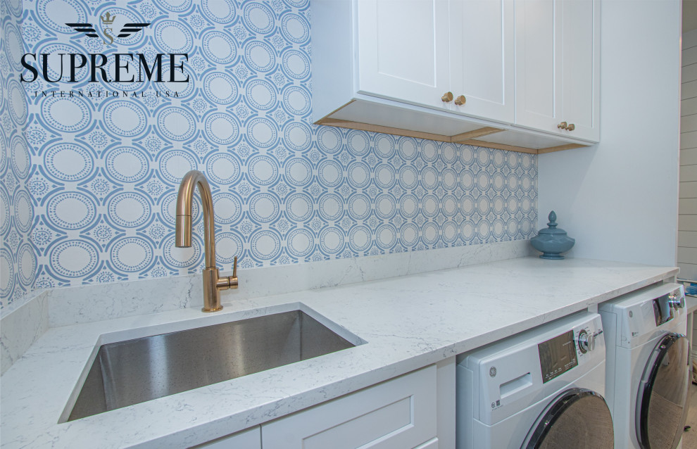 Idéer för stora vintage linjära vitt tvättstugor enbart för tvätt, med en undermonterad diskho, skåp i shakerstil, vita skåp, bänkskiva i kvarts, blå väggar, klinkergolv i porslin, en tvättmaskin och torktumlare bredvid varandra och brunt golv