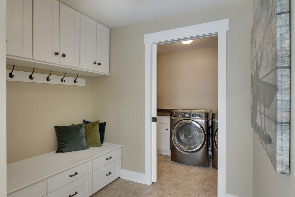 Example of a mid-sized classic porcelain tile dedicated laundry room design in Minneapolis with a single-bowl sink, recessed-panel cabinets, white cabinets, laminate countertops, beige walls and a side-by-side washer/dryer