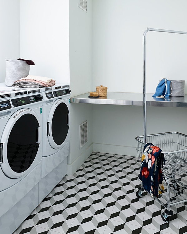 Idéer för mellanstora funkis l-formade tvättstugor enbart för tvätt, med bänkskiva i rostfritt stål, gröna väggar, klinkergolv i keramik och en tvättmaskin och torktumlare bredvid varandra