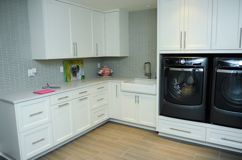 Idéer för mellanstora funkis l-formade tvättstugor enbart för tvätt, med en rustik diskho, skåp i shakerstil, vita skåp, bänkskiva i kvarts, grå väggar, klinkergolv i porslin och en tvättmaskin och torktumlare bredvid varandra