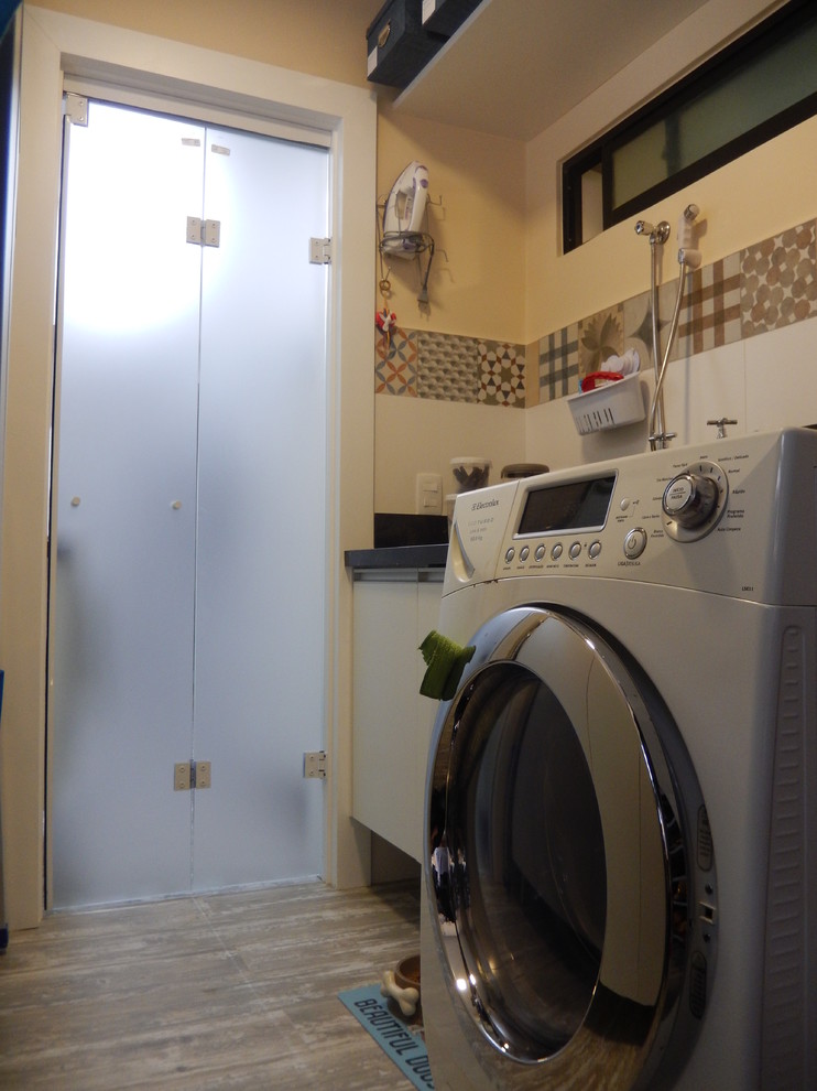 Ejemplo de cuarto de lavado lineal contemporáneo pequeño con fregadero bajoencimera, puertas de armario blancas, encimera de mármol, suelo de baldosas de porcelana y paredes beige