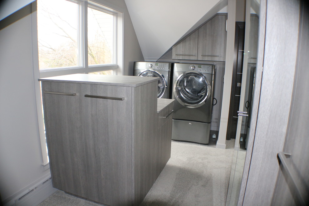 Foto di un ripostiglio-lavanderia contemporaneo di medie dimensioni con ante lisce, ante grigie, top in legno, pareti grigie, moquette e lavatrice e asciugatrice affiancate