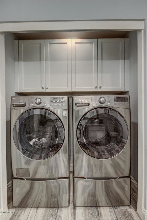 Diseño de armario lavadero lineal contemporáneo pequeño con armarios estilo shaker, puertas de armario blancas, paredes grises, suelo de baldosas de porcelana y lavadora y secadora juntas