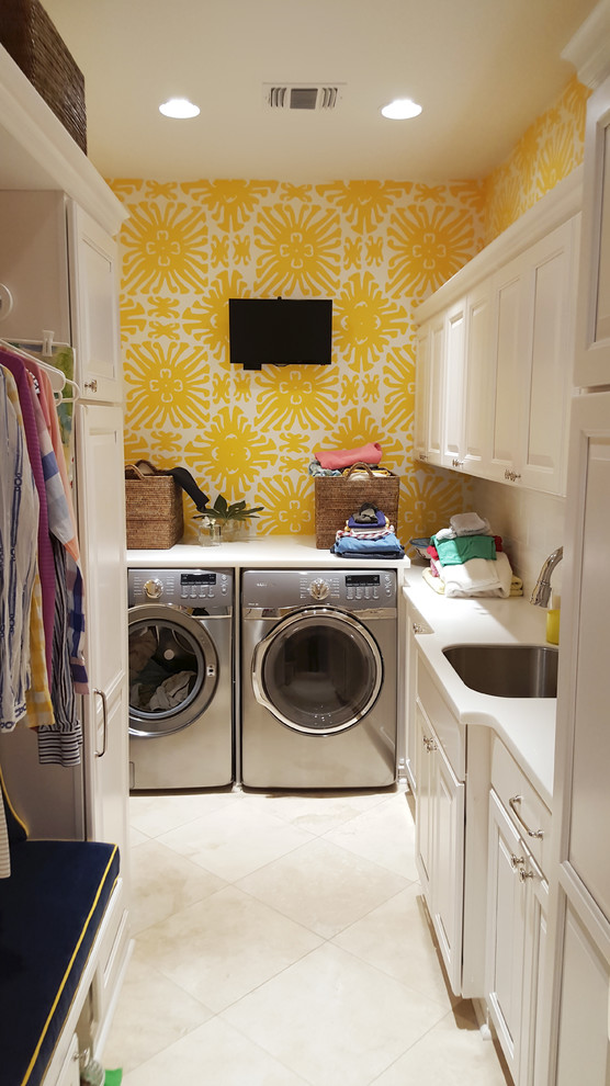 Multifunktionaler, Kleiner Stilmix Hauswirtschaftsraum mit Unterbauwaschbecken, profilierten Schrankfronten, weißen Schränken, gelber Wandfarbe, Keramikboden und Waschmaschine und Trockner nebeneinander in New Orleans