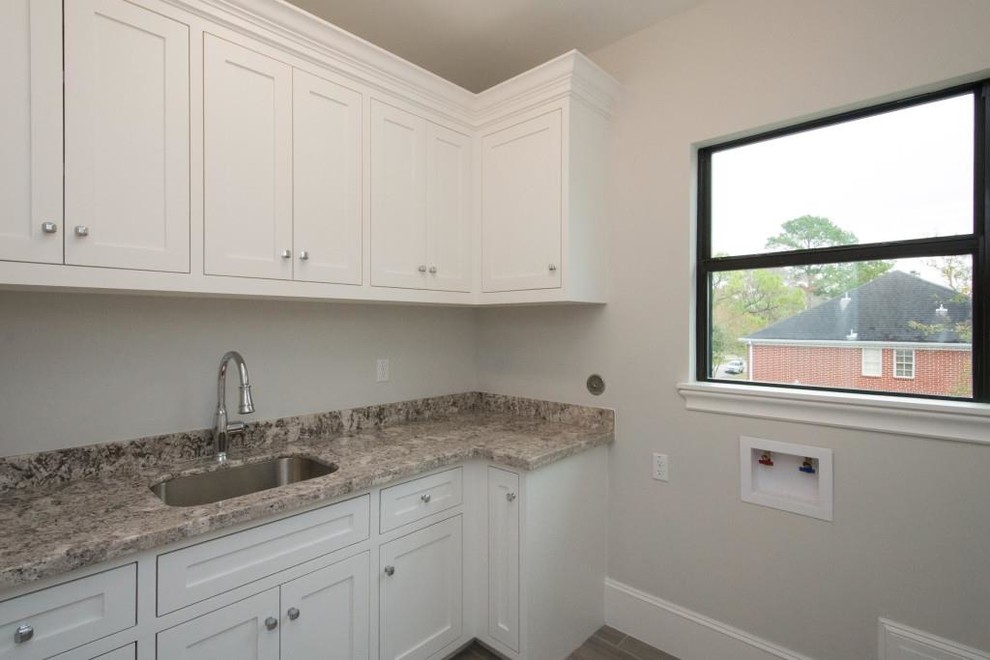 Example of a large trendy l-shaped slate floor and gray floor utility room design in Houston with a drop-in sink, shaker cabinets, white cabinets, granite countertops, gray walls, a side-by-side washer/dryer and gray countertops