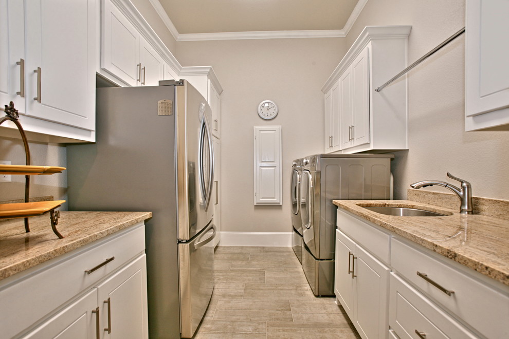 Large trendy galley ceramic tile dedicated laundry room photo in Dallas with an undermount sink, raised-panel cabinets, white cabinets, granite countertops, beige walls and a side-by-side washer/dryer