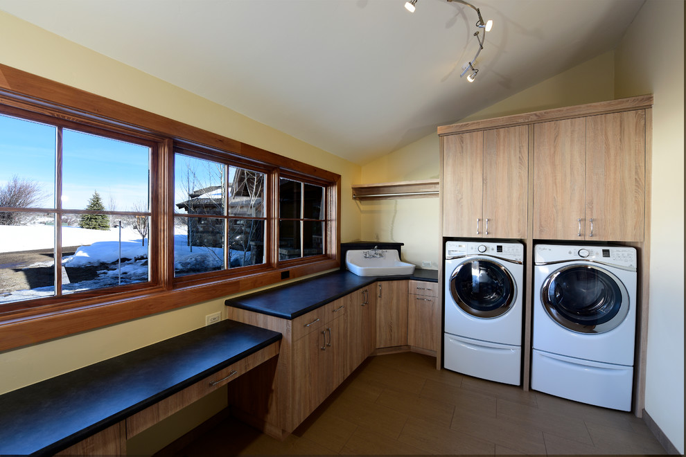 Foto di una sala lavanderia design di medie dimensioni con lavello stile country, ante lisce, ante beige, top in laminato, lavatrice e asciugatrice affiancate e pavimento marrone