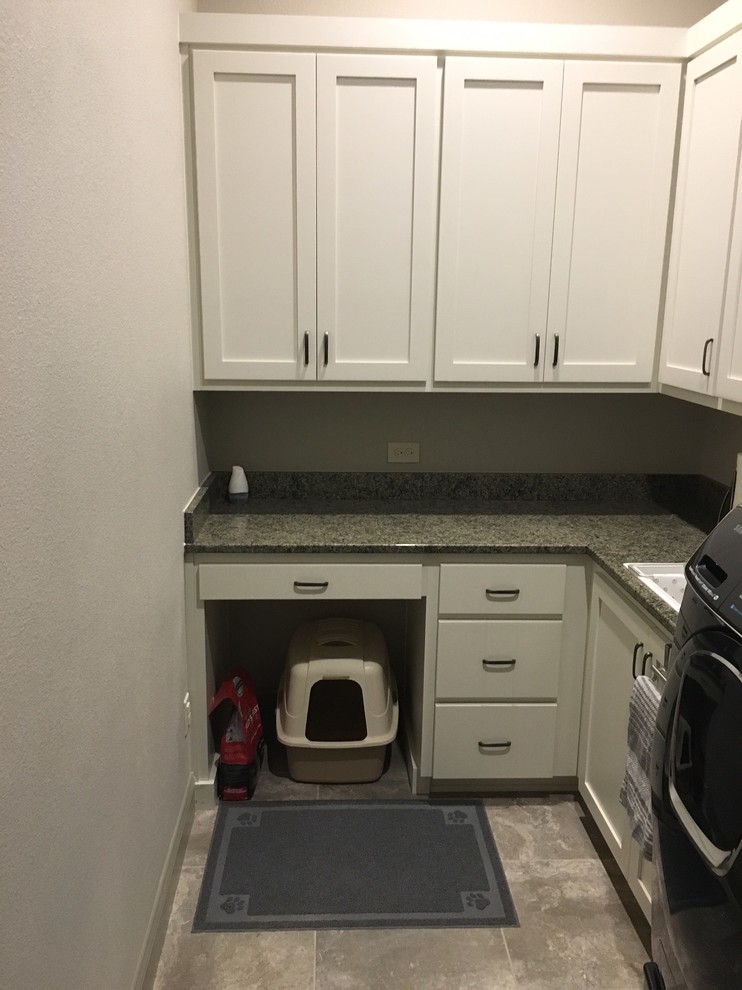 Inspiration for a small traditional l-shaped utility room in Austin with a built-in sink, recessed-panel cabinets, white cabinets, granite worktops, grey walls, concrete flooring, a side by side washer and dryer and grey floors.