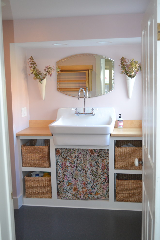 Foto på ett mellanstort lantligt grovkök, med en rustik diskho, öppna hyllor, vita skåp, träbänkskiva, rosa väggar, vinylgolv, en tvättpelare och brunt golv