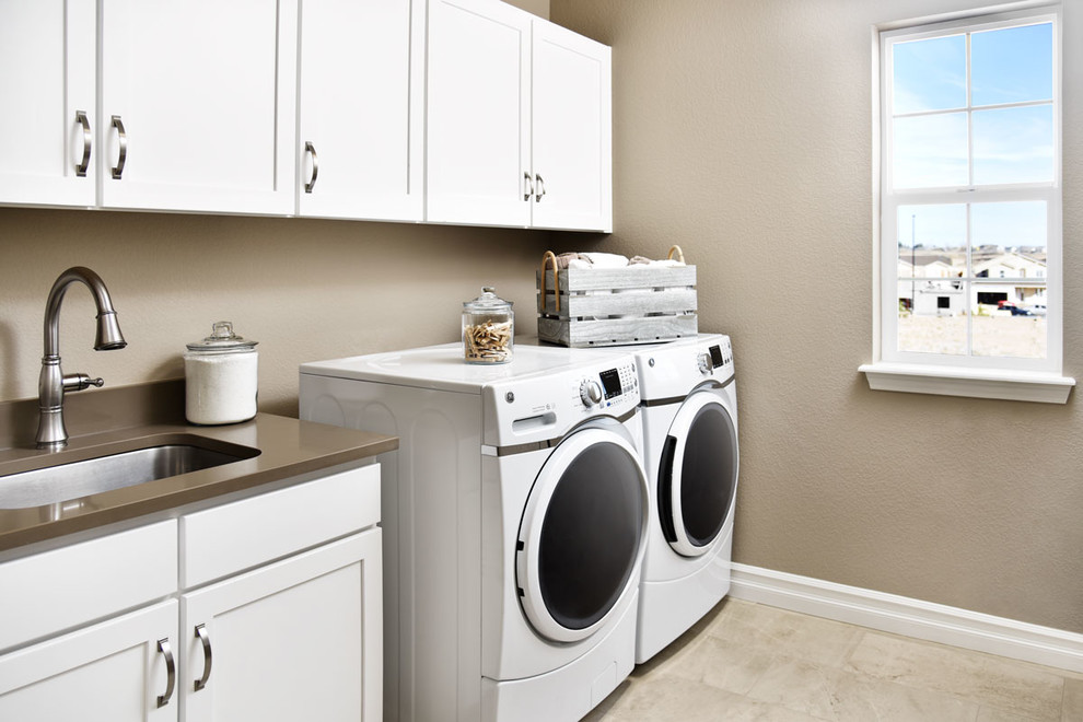 Modelo de cuarto de lavado actual con puertas de armario blancas y lavadora y secadora juntas