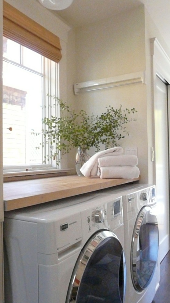 Idee per una piccola lavanderia multiuso tradizionale con top in legno, pareti bianche, parquet scuro e lavatrice e asciugatrice affiancate