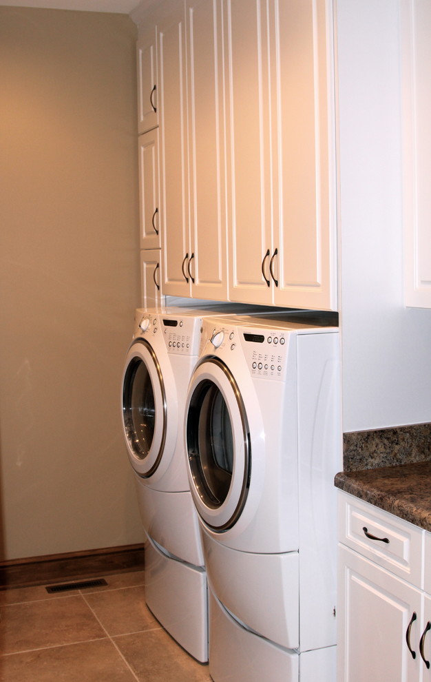 Small elegant porcelain tile dedicated laundry room photo in Nashville with raised-panel cabinets, white cabinets, laminate countertops, a side-by-side washer/dryer and white walls