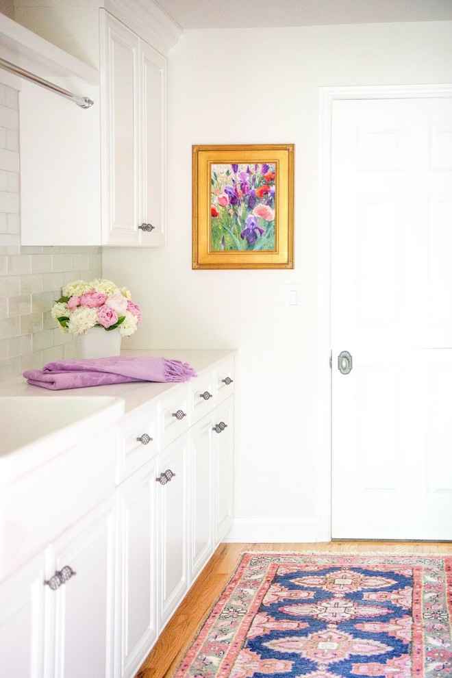 Immagine di una lavanderia moderna con lavello stile country, pareti bianche e parquet chiaro