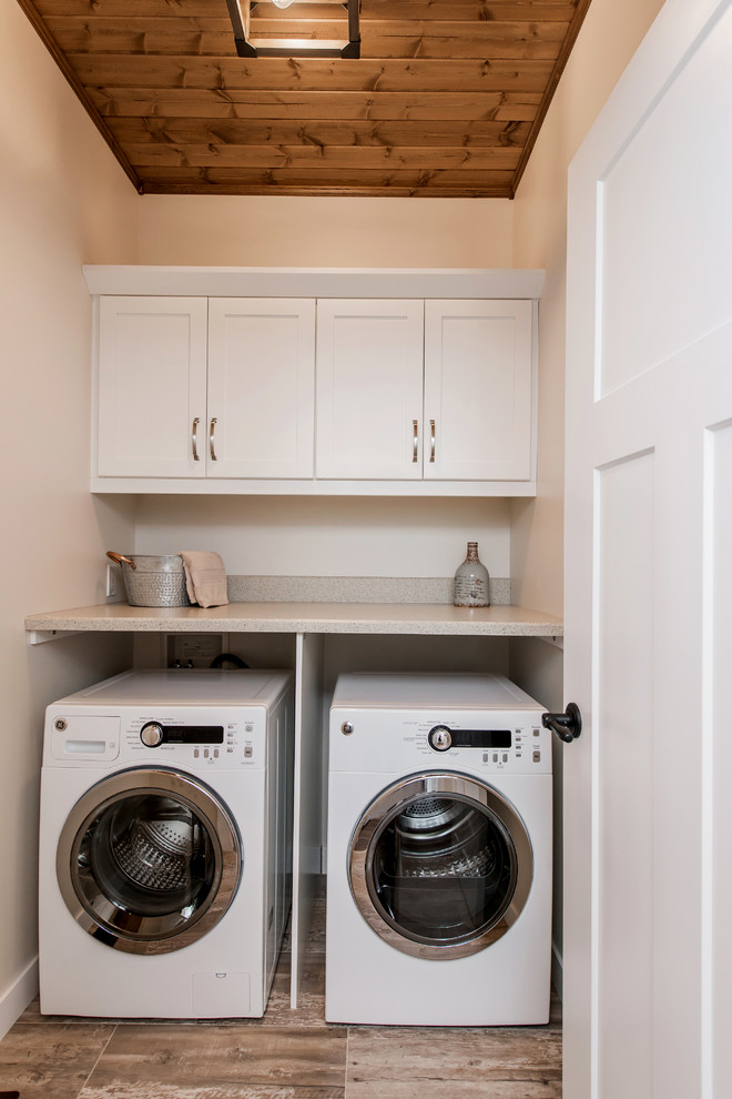 Small rustic single-wall laundry cupboard in Other with shaker cabinets, white cabinets, beige walls, porcelain flooring, a side by side washer and dryer, brown floors and beige worktops.