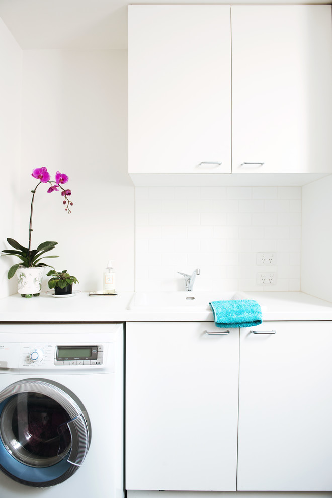 Inspiration for a large contemporary single-wall ceramic tile utility room remodel in Melbourne with a single-bowl sink, flat-panel cabinets, white cabinets, quartz countertops, white walls, a side-by-side washer/dryer and white countertops