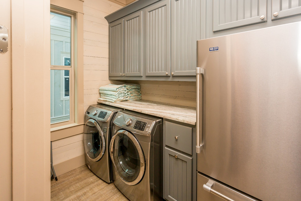 Idee per una sala lavanderia stile marino con ante blu, top in granito, pareti beige, pavimento in vinile e lavatrice e asciugatrice affiancate