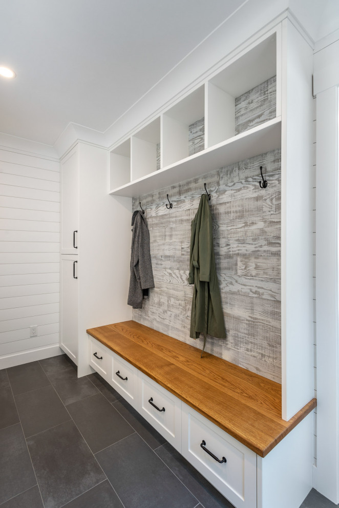 バンクーバーにある中くらいなトランジショナルスタイルのおしゃれな家事室 (I型、シェーカースタイル扉のキャビネット、白いキャビネット、白い壁、グレーの床) の写真