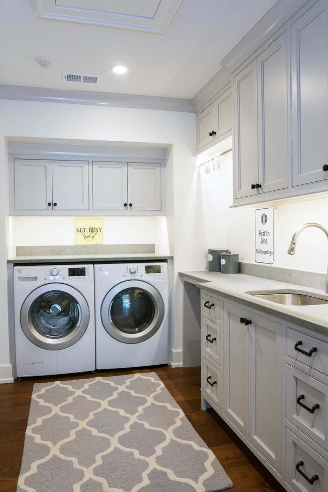 Exempel på en mellanstor klassisk tvättstuga, med luckor med profilerade fronter, svarta skåp, blå väggar och vitt golv