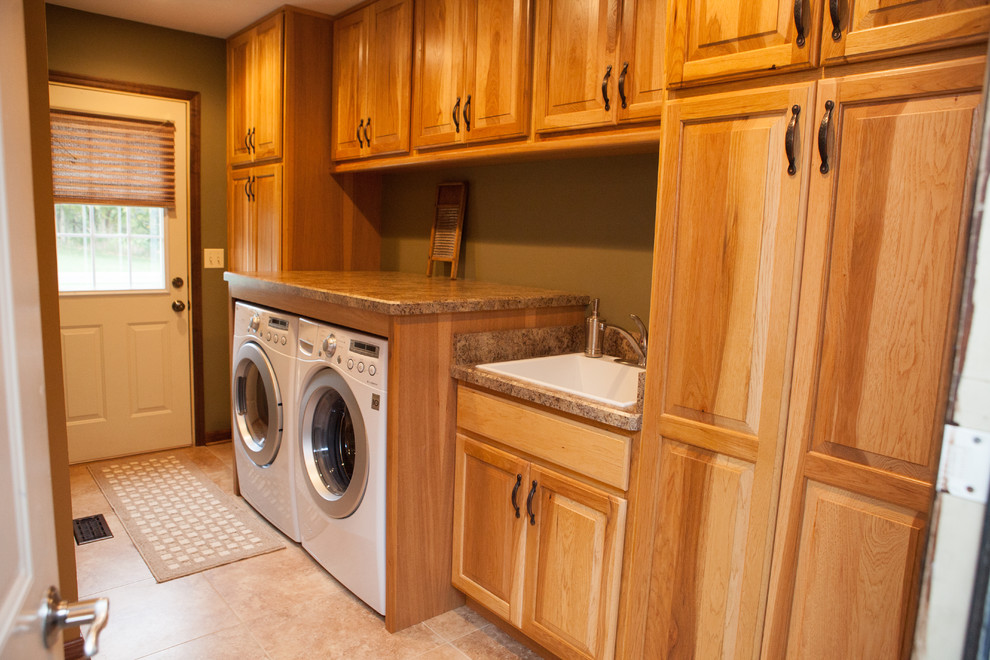 Inspiration for a mid-sized timeless u-shaped light wood floor laundry room remodel in Chicago with an undermount sink, raised-panel cabinets, granite countertops, beige backsplash, stone tile backsplash and medium tone wood cabinets