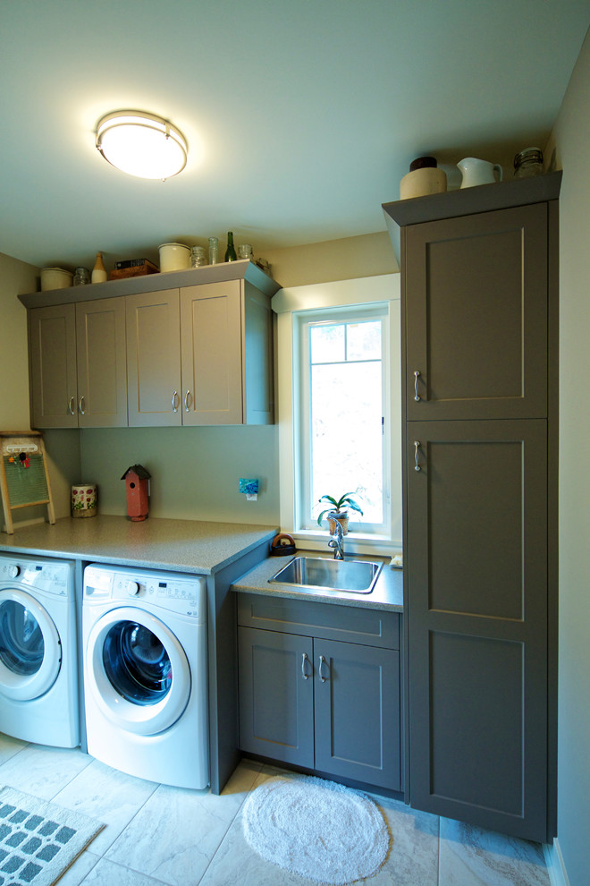 Idéer för att renovera en mellanstor vintage linjär tvättstuga enbart för tvätt, med en nedsänkt diskho, skåp i shakerstil, gröna skåp, laminatbänkskiva, gröna väggar, klinkergolv i porslin och en tvättmaskin och torktumlare bredvid varandra
