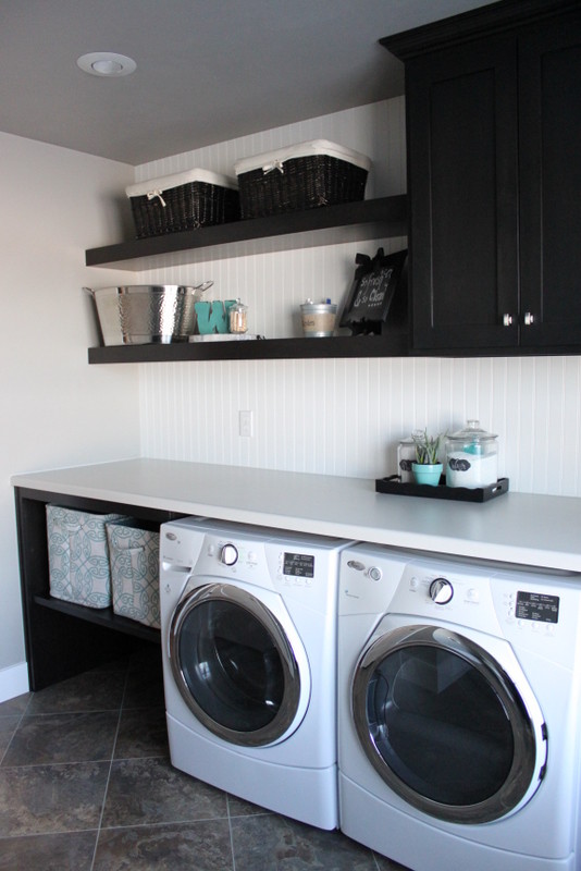 Idéer för att renovera en stor amerikansk parallell tvättstuga enbart för tvätt, med skåp i shakerstil, svarta skåp, laminatbänkskiva, grå väggar och en tvättmaskin och torktumlare bredvid varandra