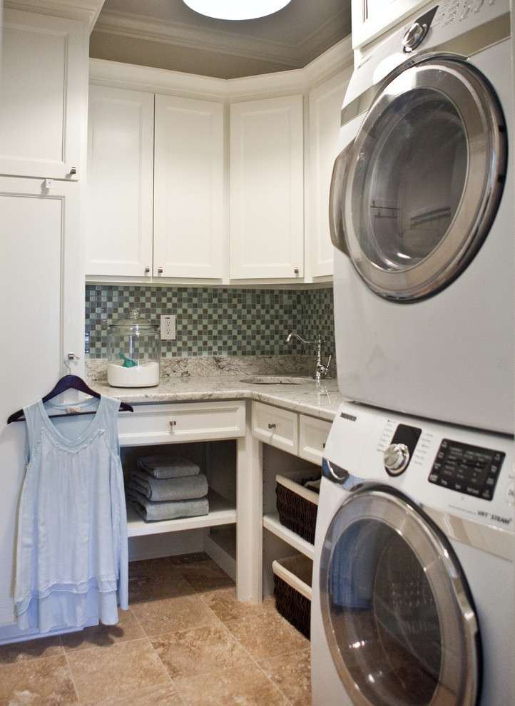 アトランタにある低価格の小さなトラディショナルスタイルのおしゃれな洗濯室 (ll型、アンダーカウンターシンク、シェーカースタイル扉のキャビネット、白いキャビネット、御影石カウンター、ベージュの壁、ライムストーンの床、上下配置の洗濯機・乾燥機) の写真