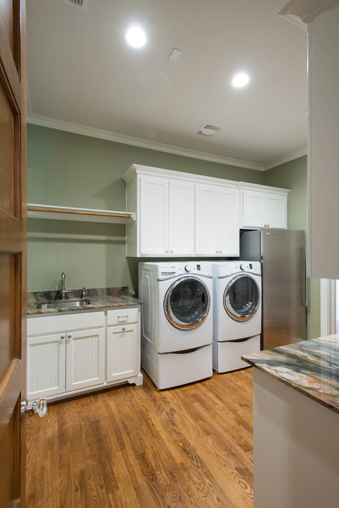 Large arts and crafts galley medium tone wood floor utility room photo in Dallas with an undermount sink, flat-panel cabinets, white cabinets, quartzite countertops, green walls and a side-by-side washer/dryer