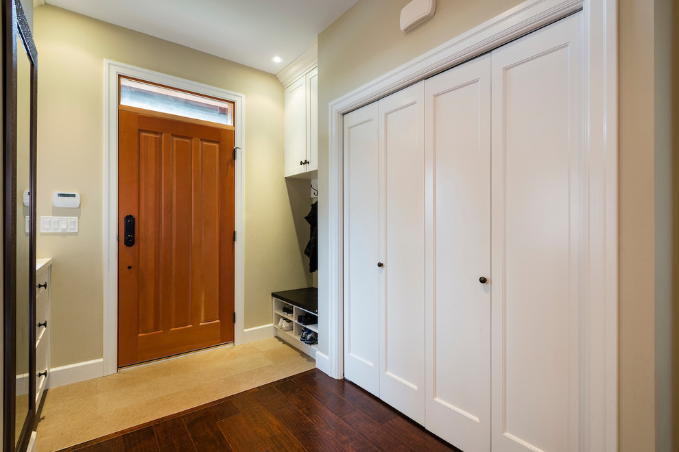 Example of an arts and crafts dark wood floor and brown floor utility room design in Vancouver with shaker cabinets, white cabinets, quartz countertops and beige walls