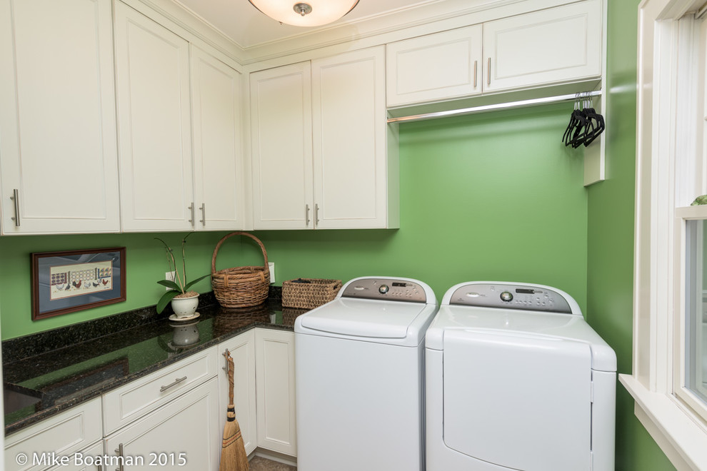 Foto di una piccola lavanderia multiuso con ante con riquadro incassato, ante bianche, pareti verdi, pavimento con piastrelle in ceramica e lavatrice e asciugatrice affiancate