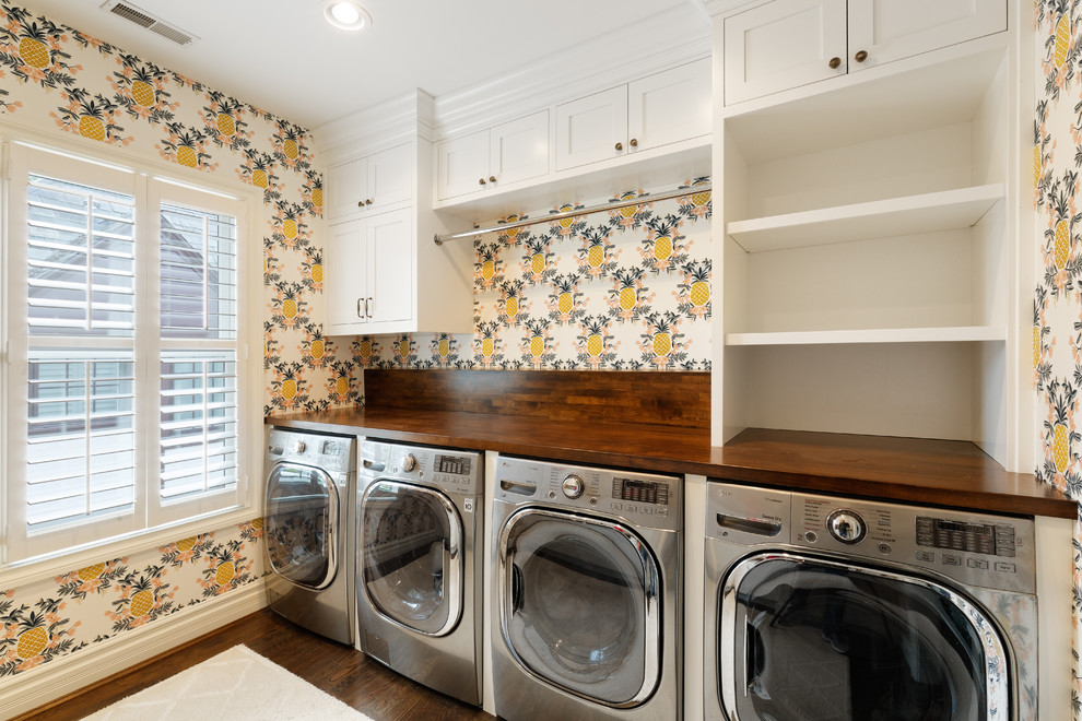 Esempio di una sala lavanderia tradizionale di medie dimensioni con ante a filo, ante bianche, top in legno, pareti gialle, parquet scuro, lavatrice e asciugatrice affiancate, pavimento marrone e top marrone