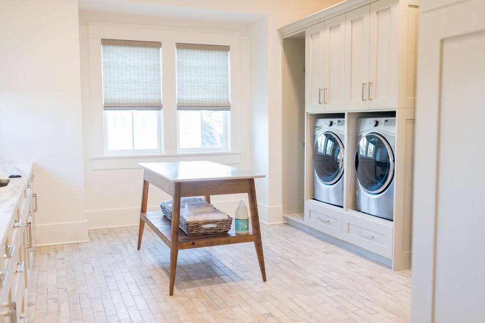 Immagine di una sala lavanderia stile marino con lavello sottopiano, ante in stile shaker, ante beige, pareti bianche, lavatrice e asciugatrice affiancate, pavimento beige e top beige