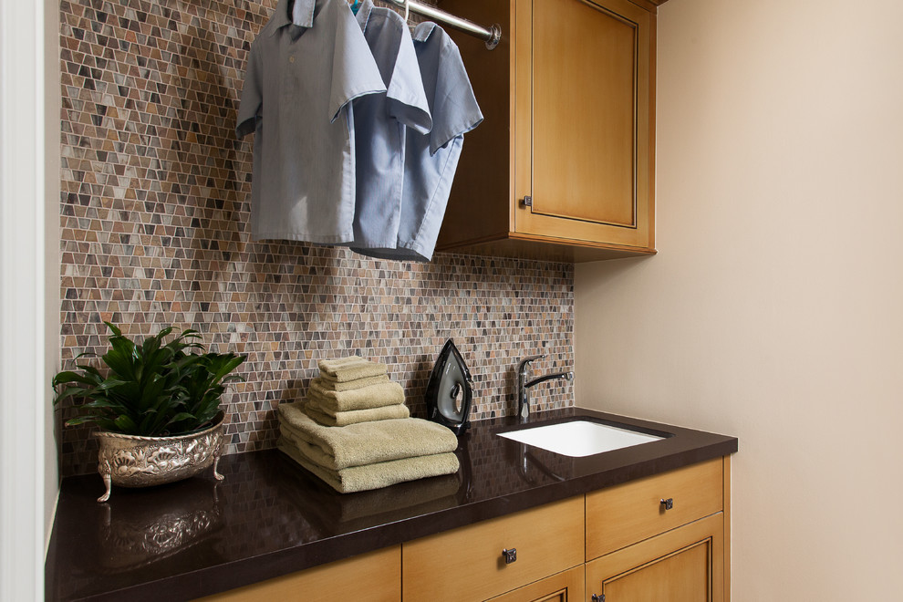 Laundry room - traditional laundry room idea in Los Angeles with an undermount sink, multicolored walls, recessed-panel cabinets and medium tone wood cabinets