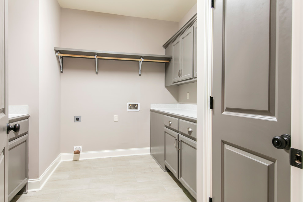 Example of a mid-sized arts and crafts single-wall ceramic tile and gray floor dedicated laundry room design in New Orleans with an utility sink, flat-panel cabinets, gray cabinets, laminate countertops, gray walls, a side-by-side washer/dryer and white countertops