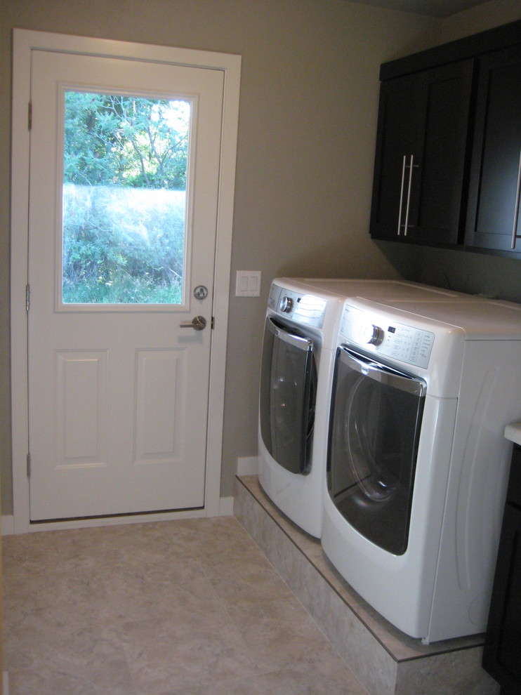 Esempio di una sala lavanderia minimal di medie dimensioni con ante in stile shaker, ante in legno bruno, top in laminato, pareti beige, pavimento in vinile e lavatrice e asciugatrice affiancate