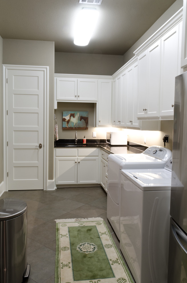 This is an example of an expansive traditional l-shaped utility room in Austin with a submerged sink, recessed-panel cabinets, white cabinets, granite worktops, beige walls, porcelain flooring and a side by side washer and dryer.