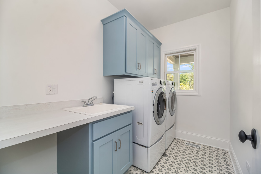 Foto di una sala lavanderia country di medie dimensioni con lavello da incasso, ante in stile shaker, pareti bianche, lavatrice e asciugatrice affiancate e top bianco