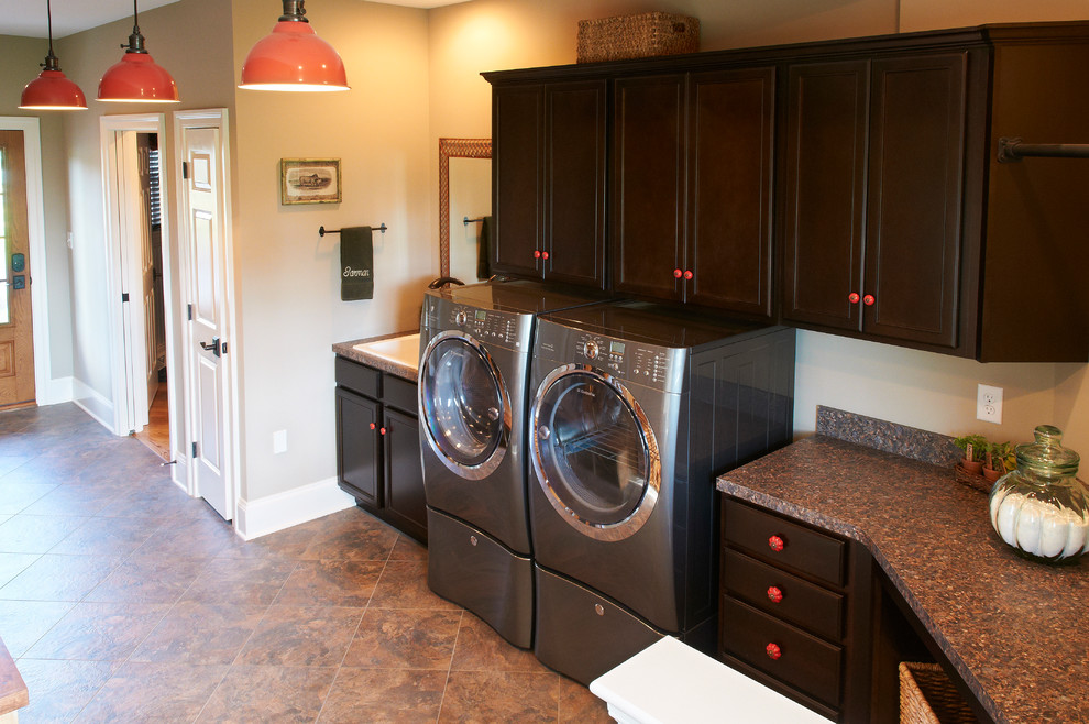 他の地域にあるラグジュアリーなトラディショナルスタイルのおしゃれな洗濯室 (コの字型、スロップシンク、濃色木目調キャビネット、ベージュの壁、左右配置の洗濯機・乾燥機) の写真