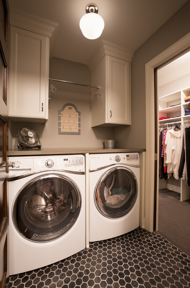 Foto på en vintage tvättstuga enbart för tvätt, med luckor med infälld panel, vita skåp, grå väggar och en tvättmaskin och torktumlare bredvid varandra