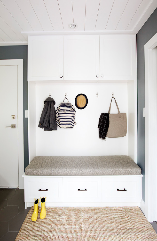 Design ideas for a medium sized nautical single-wall utility room in Vancouver with a submerged sink, shaker cabinets, white cabinets, engineered stone countertops, grey walls, ceramic flooring, a stacked washer and dryer and grey floors.