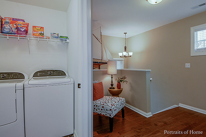 Small traditional single-wall separated utility room in Chicago with ceramic flooring, beige walls and a side by side washer and dryer.