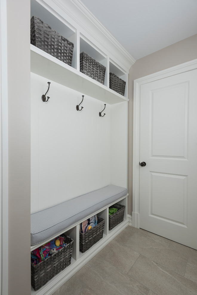 Modern inredning av en mellanstor vita linjär vitt liten tvättstuga, med en dubbel diskho, luckor med infälld panel, vita skåp, granitbänkskiva, beige väggar, laminatgolv, en tvättmaskin och torktumlare bredvid varandra och grått golv