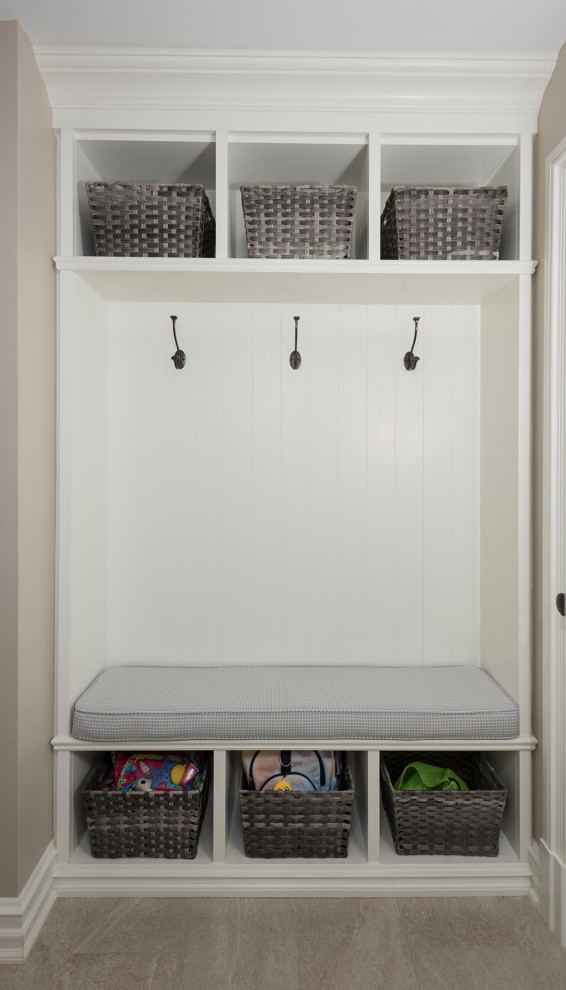 Diseño de armario lavadero lineal moderno de tamaño medio con armarios con paneles empotrados, puertas de armario blancas, paredes beige, lavadora y secadora juntas, suelo laminado y suelo gris